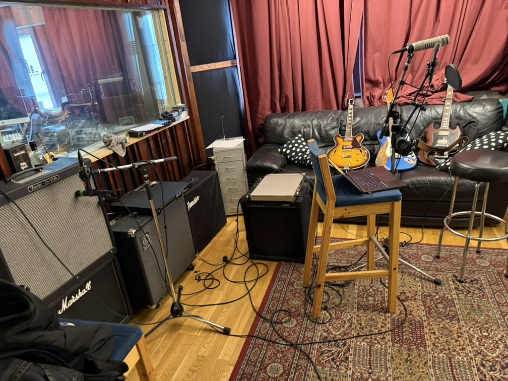 Studiorummet med förstärkare, mikrofoner och gitarrer
